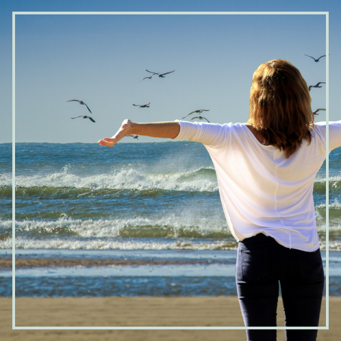 an image of a free woman facing the sea.