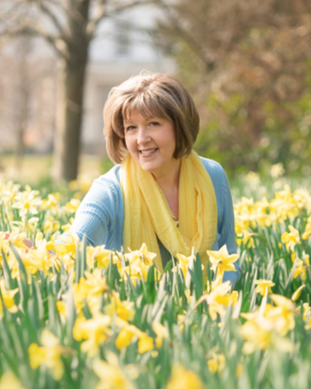 A photo of debs smiling in the middle of a flower field