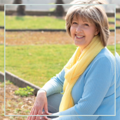 debs smiling wearing blue shirt and yellow scarf